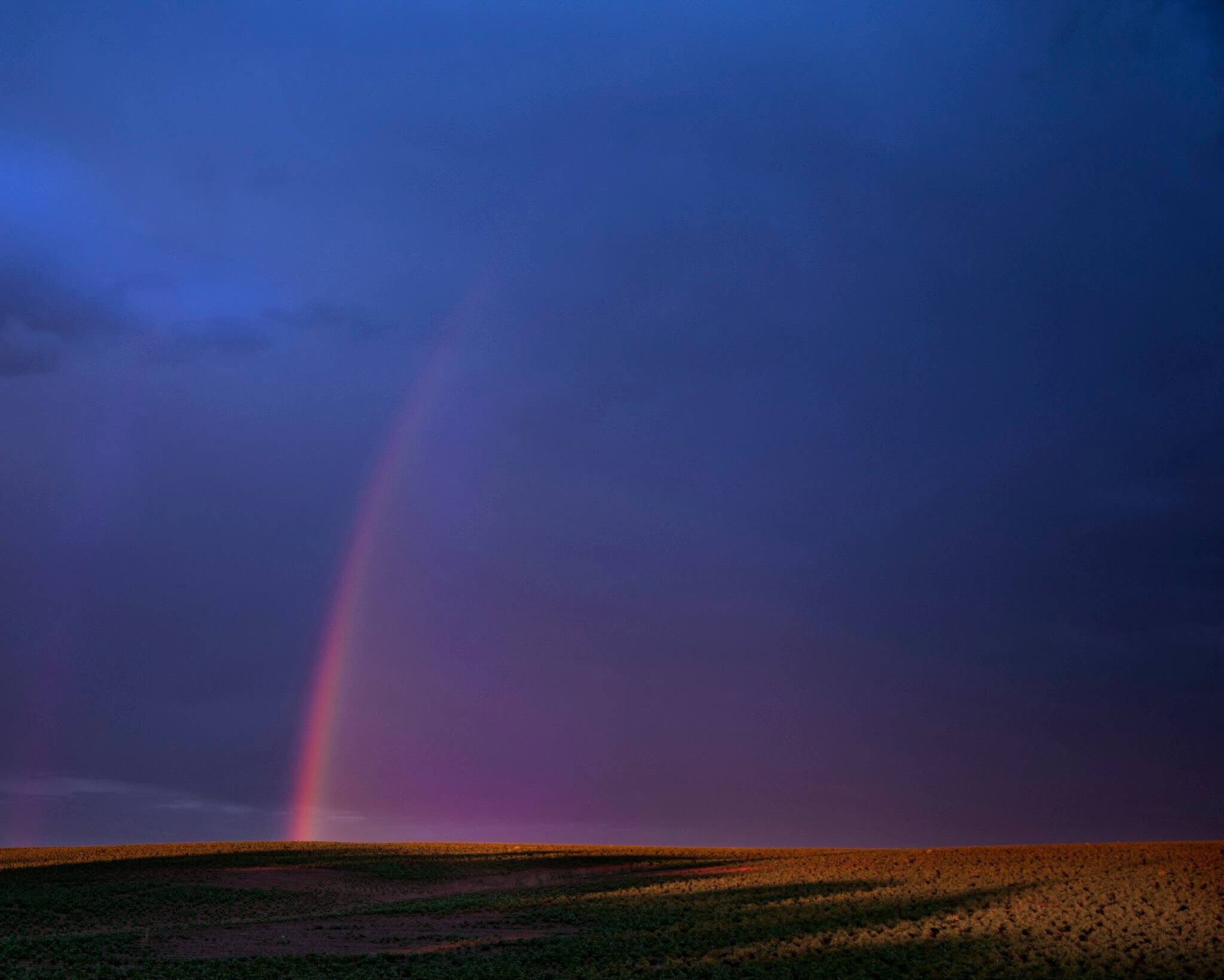 Rainbow over open land photographed by Rodney Marullo