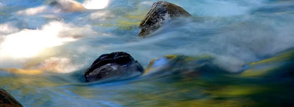Water moving around stone photographed by Rodney Marullo